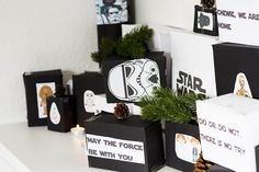 several black and white boxes with christmas decorations on the top one is for star wars