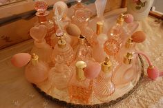 an assortment of perfume bottles sitting on top of a wooden table next to a mirror