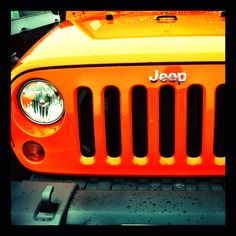 an orange jeep with the word jeep on it's front grill and headlights are shown