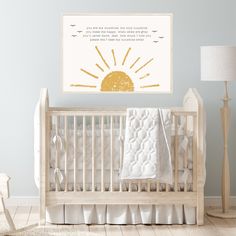 a baby's room with a crib, lamp and wall hanging on the wall