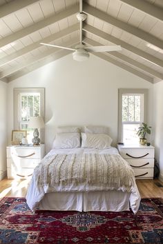 a bedroom with a bed, dressers and rug in it's center area