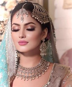 a woman wearing a bridal outfit and jewelry