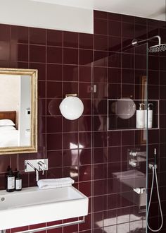 a bathroom with a sink, mirror and shower head in the corner next to it