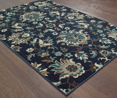 a blue area rug with flowers and leaves on the bottom in a wood floored room