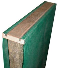 a piece of wood sitting on top of a green tarp next to a white wall