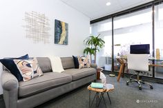 a living room filled with furniture next to a large glass wall window covered in lots of windows