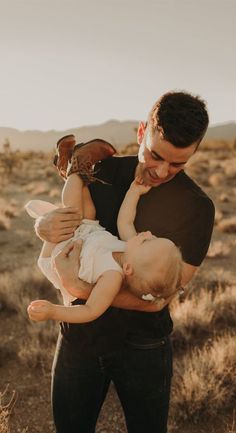 a man holding a baby in the desert