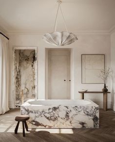 a marble bathtub sits in the middle of a room with wooden floors and walls