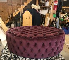 a large purple ottoman sitting on top of a black and white rug