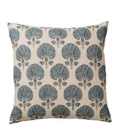 a blue and white pillow with an intricate design on the front, featuring large fan shaped leaves