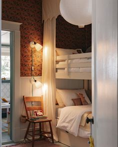 bunk beds in a small room with curtains on the ceiling and lights hanging from the ceiling