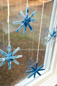 three snowflakes hanging from a window