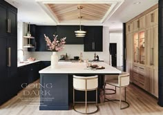 a large kitchen with black cabinets and white counter tops is featured in the magazine going dark