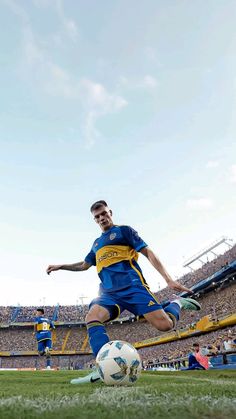 a man kicking a soccer ball on top of a field