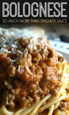 spaghetti with meat sauce and parmesan cheese on the top is served in a white plate