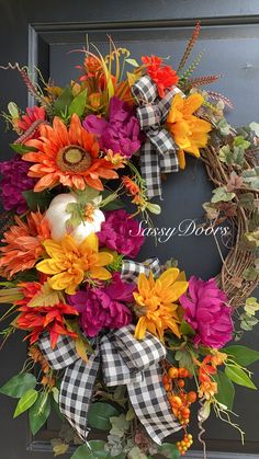 a wreath with flowers and pumpkins on it