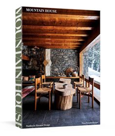 the mountain house book is on display in front of a stone wall and wooden ceiling