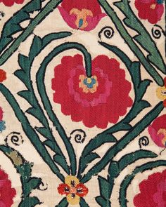 an intricately designed rug with red flowers and green leaves on white ground, close up