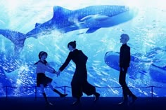 three people holding hands in front of an underwater scene with sharks and other marine creatures