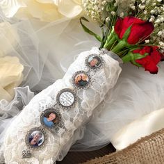 a bouquet of flowers sitting on top of a white lace covered pillow next to a red rose