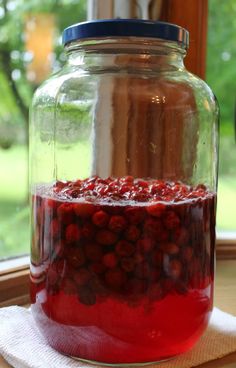 a jar filled with red liquid sitting on top of a table