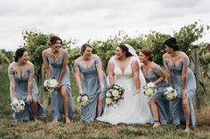 a group of women standing next to each other on top of a grass covered field