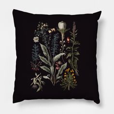 a black pillow with flowers and plants on it