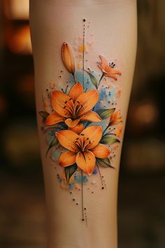 an orange flower tattoo on the side of a woman's leg with watercolors