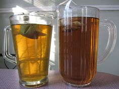 two pitchers of tea sitting on top of a table