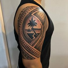 a man with a tattoo on his arm that has a palm tree in the center