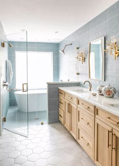 a bathroom with two sinks and a bathtub next to a walk - in shower