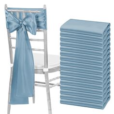 a stack of blue chair covers next to a stack of white chairs with bows on them