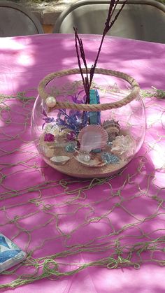 a vase filled with flowers sitting on top of a pink table cloth covered tablecloth