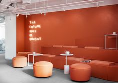 an orange and white room with stools, tables and lights on the wall in front of it