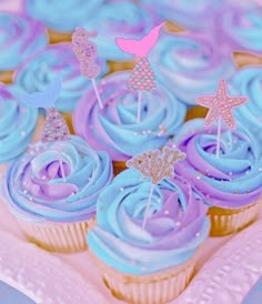 cupcakes with blue frosting and pink decorations