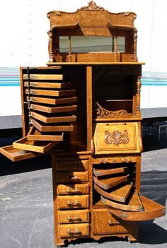 an old wooden desk with drawers and mirror on the top, in front of a train