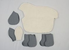 several pieces of cloth and felt are laid out on a white surface with gray feet