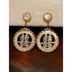 This is a lovely pair Vintage Japanese Mother of Pearl Dangle Earrings that will look amazing day and night. The round abalone post part of the earrings is surrounded by a gold-filled, beaded outer-ring as is the handcarved, dangle part of the earrings that has Japanese wording carved out. These screw back Asian-inspired earrings are really quite feminine, reflect the light beautifully and will be a nice addition to your vintage jewelry collection.  Condition: Excellent vintage condition; please see pics for details. Marks: none Dimensions: approximately 1"W x 1.75"L Yellow Gold Mother Of Pearl Earrings, Unique Round Clip-on Jewelry, Elegant Medallion Earrings For Gift, Yellow Gold Mother Of Pearl Round Earrings, Pierced Round Mother Of Pearl Jewelry, Gold Round Earrings With Mother Of Pearl, Anniversary Mother Of Pearl Round Earrings, Gold Mother Of Pearl Round Earrings, Round Mother Of Pearl Earrings For Gift