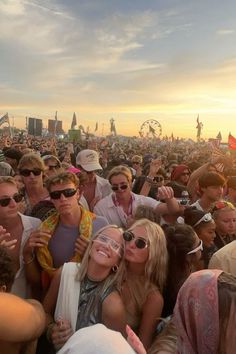 a group of people standing around each other in front of a crowd at a music festival