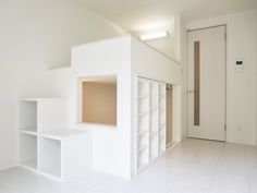 an empty room with white walls and shelves