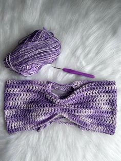 a purple crocheted headband next to a ball of yarn