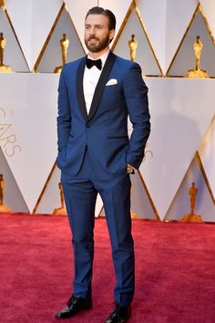 a man in a tuxedo and bow tie on the oscars red carpet