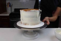 a person is cutting into a cake on a white table with a silver platter