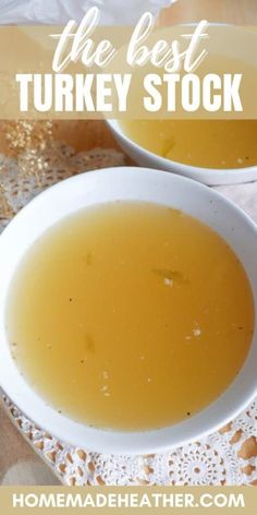 two white bowls filled with turkey stock on top of a doily next to bread