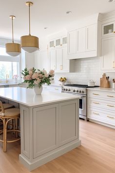 a large kitchen with white cabinets and wooden floors