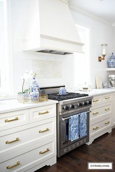 a stove top oven sitting inside of a kitchen next to white cabinets and counter tops