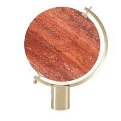 an orange marble globe on a metal stand with a gold base and two small round knobs