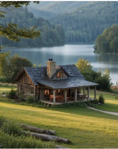 a house sitting on top of a lush green field next to a lake and forest