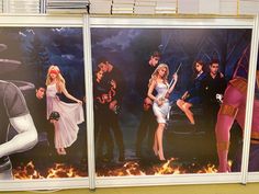 two large pictures of people in costumes on the side of a wall with fire behind them