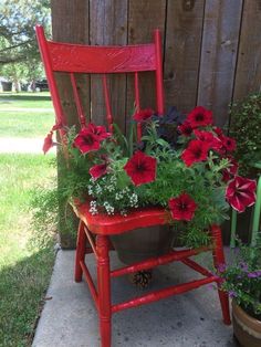 a red chair with potted flowers in it